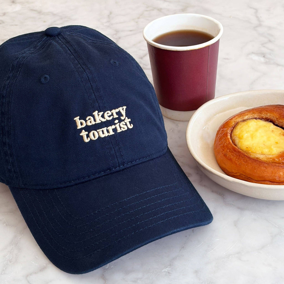 Alphabet Bags Bakery Tourist embroidered cotton baseball cap in navy blue.