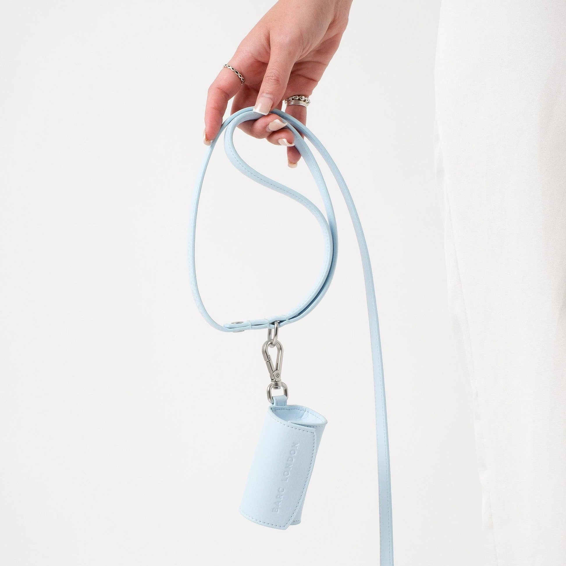 Light blue lanyard with a small pouch held by a hand on a white background