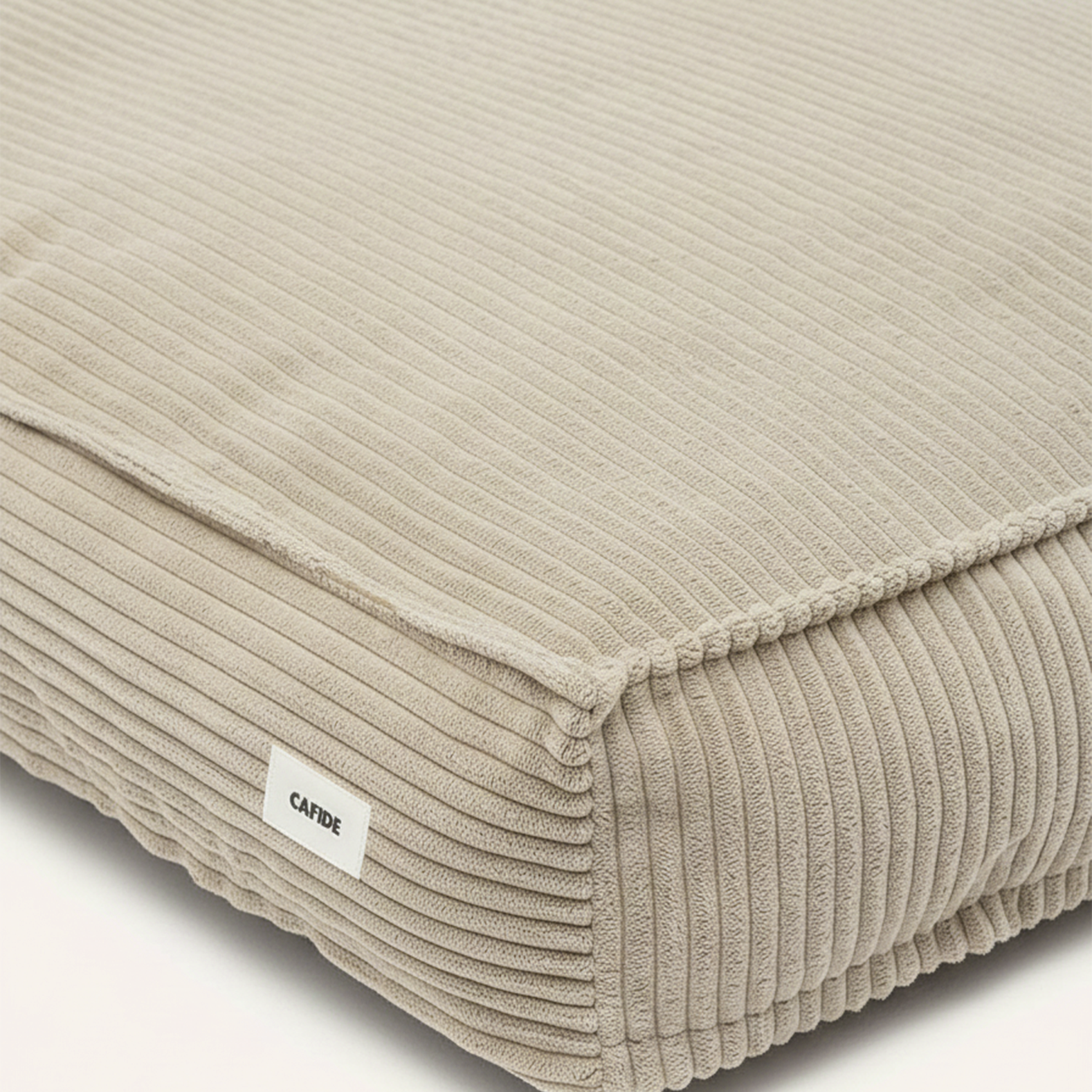 Beige ribbed cushion with a visible brand label on a white background