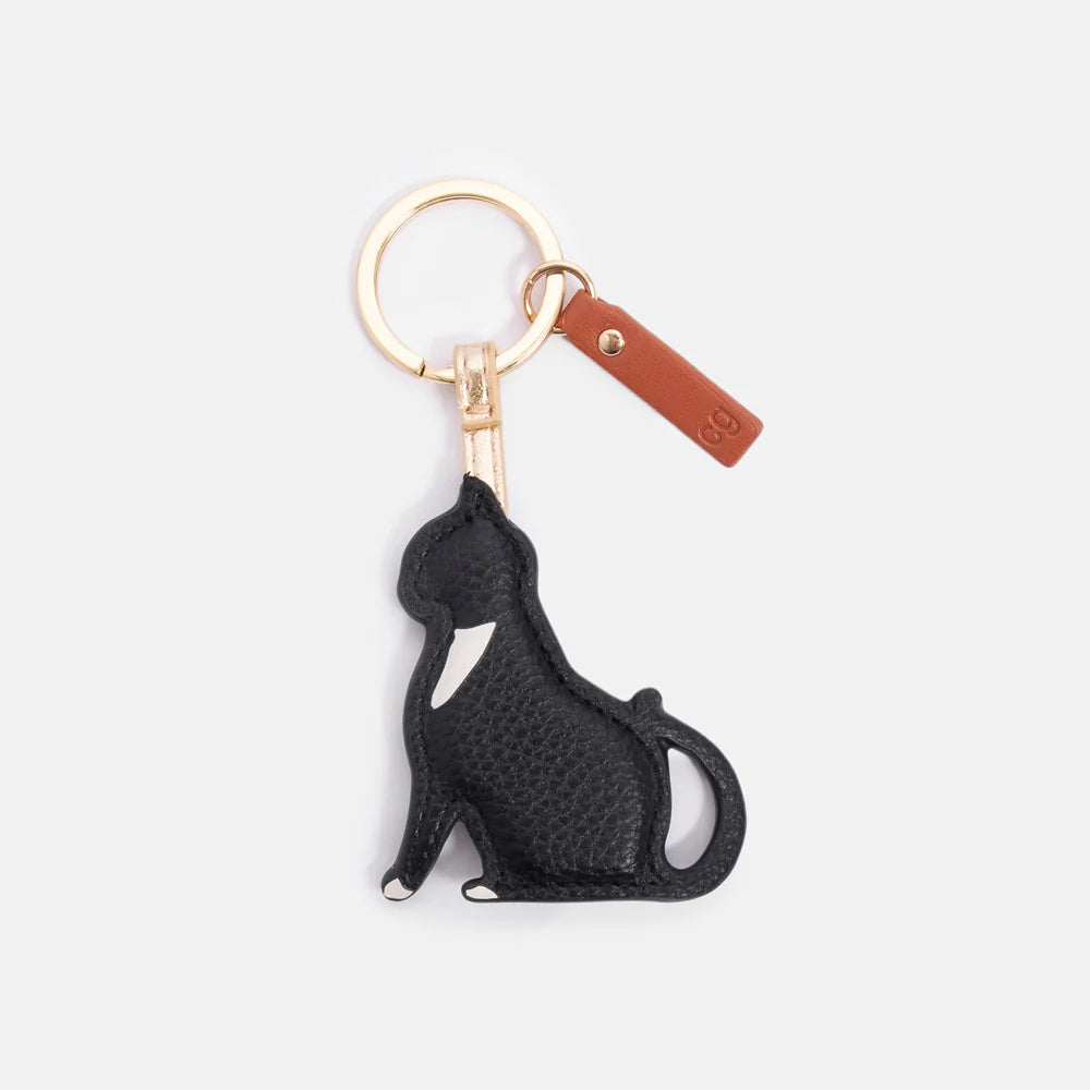 Black and white tuxedo cat keyring with gold-tone hardware and tan leather-look tab.