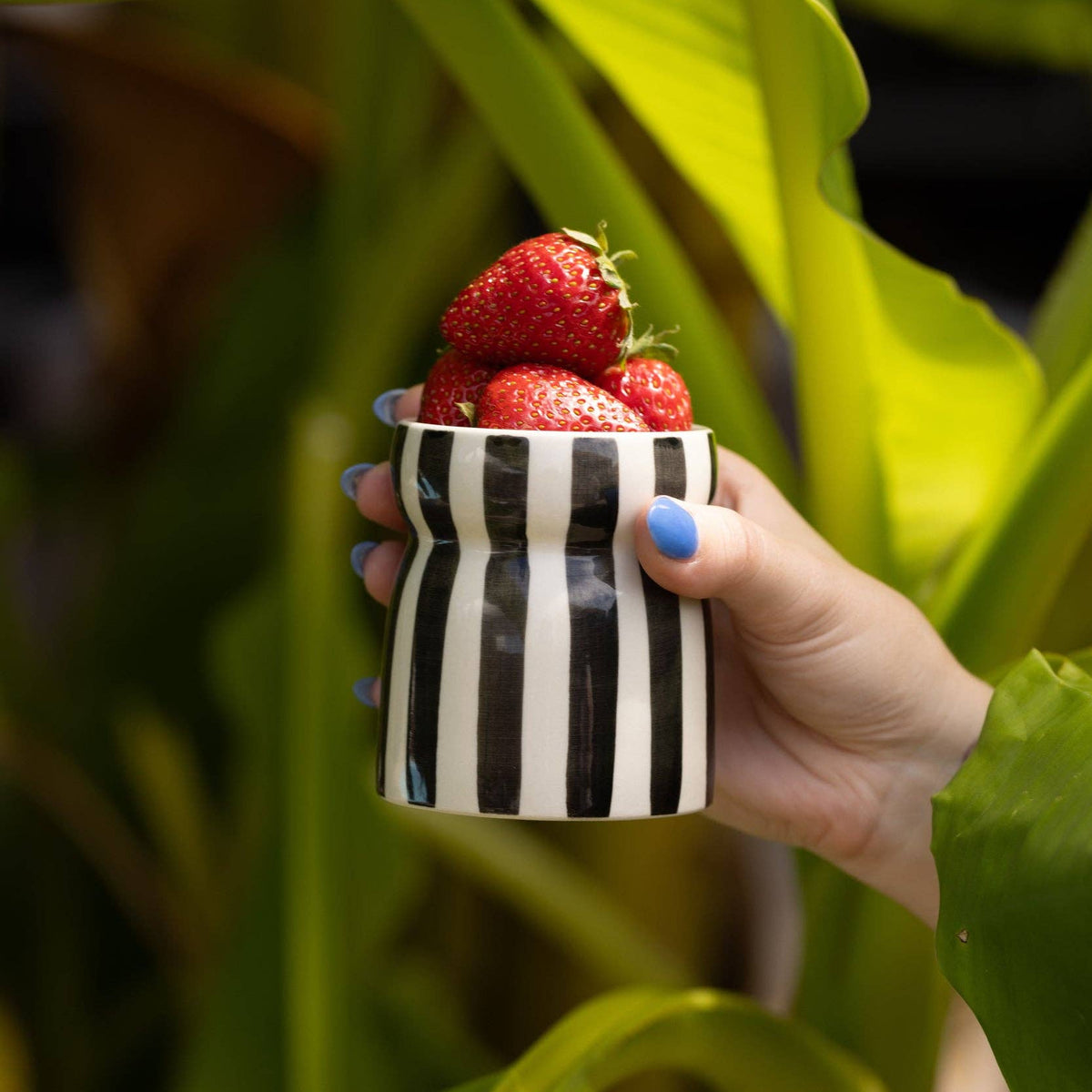 Hand-painted black and cream striped Paddywax Cabana ceramic candle.