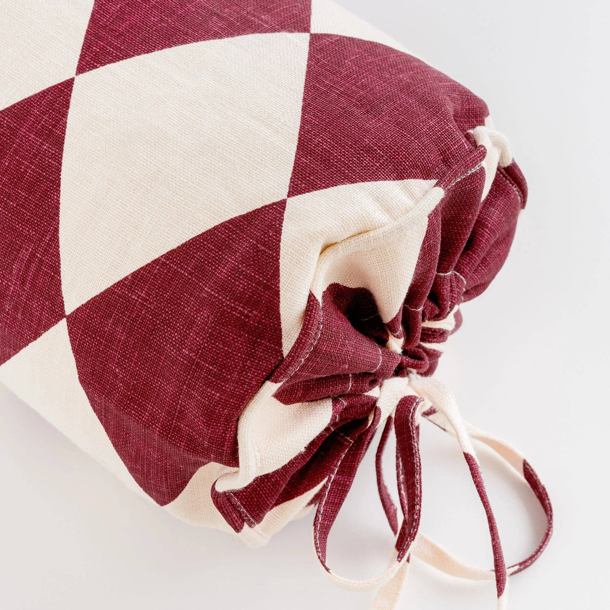 Claret and cream Harlequin designer bolster cushion in 100% linen.
