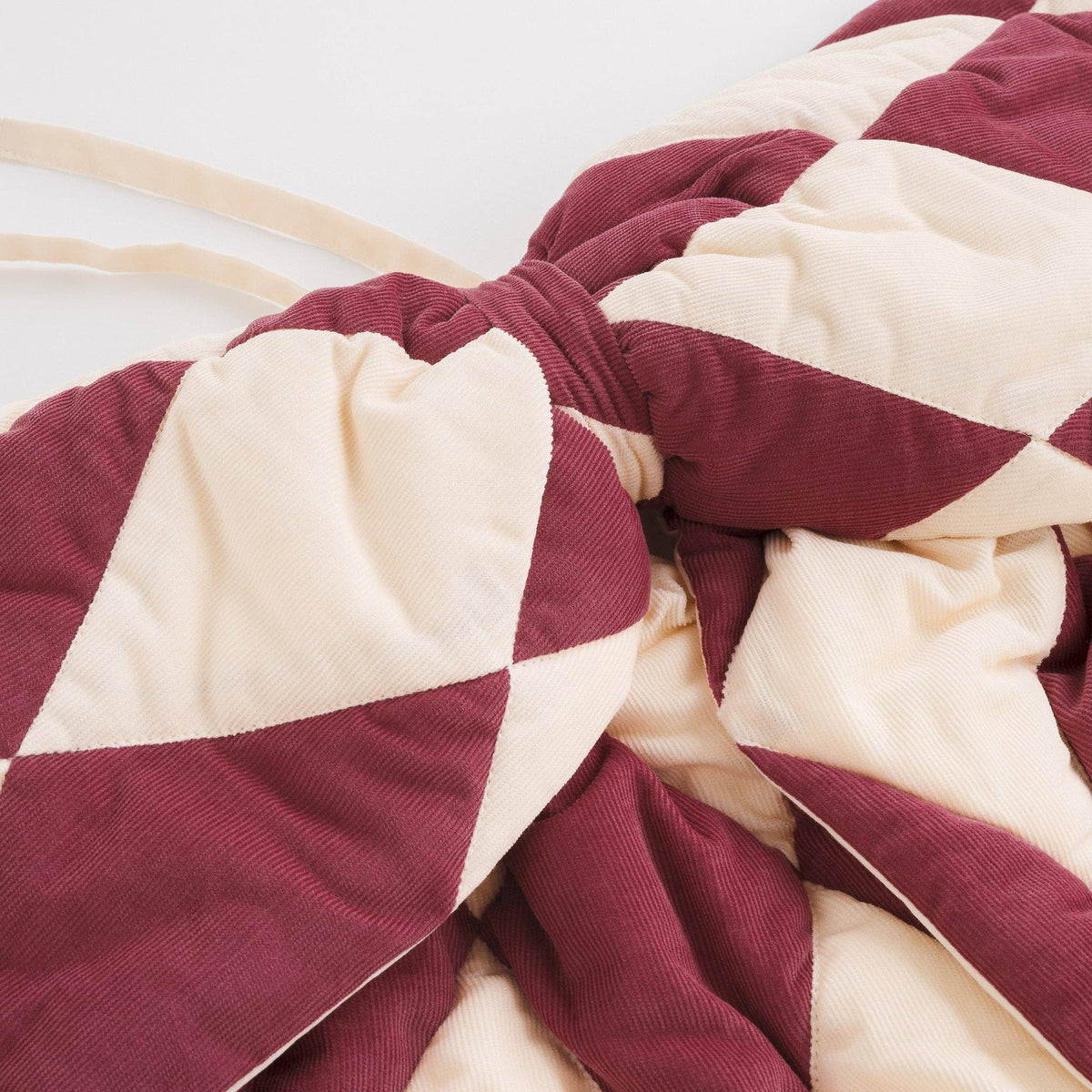 Quilted claret and cream Harlequin fabric bow for colourful designer interiors.