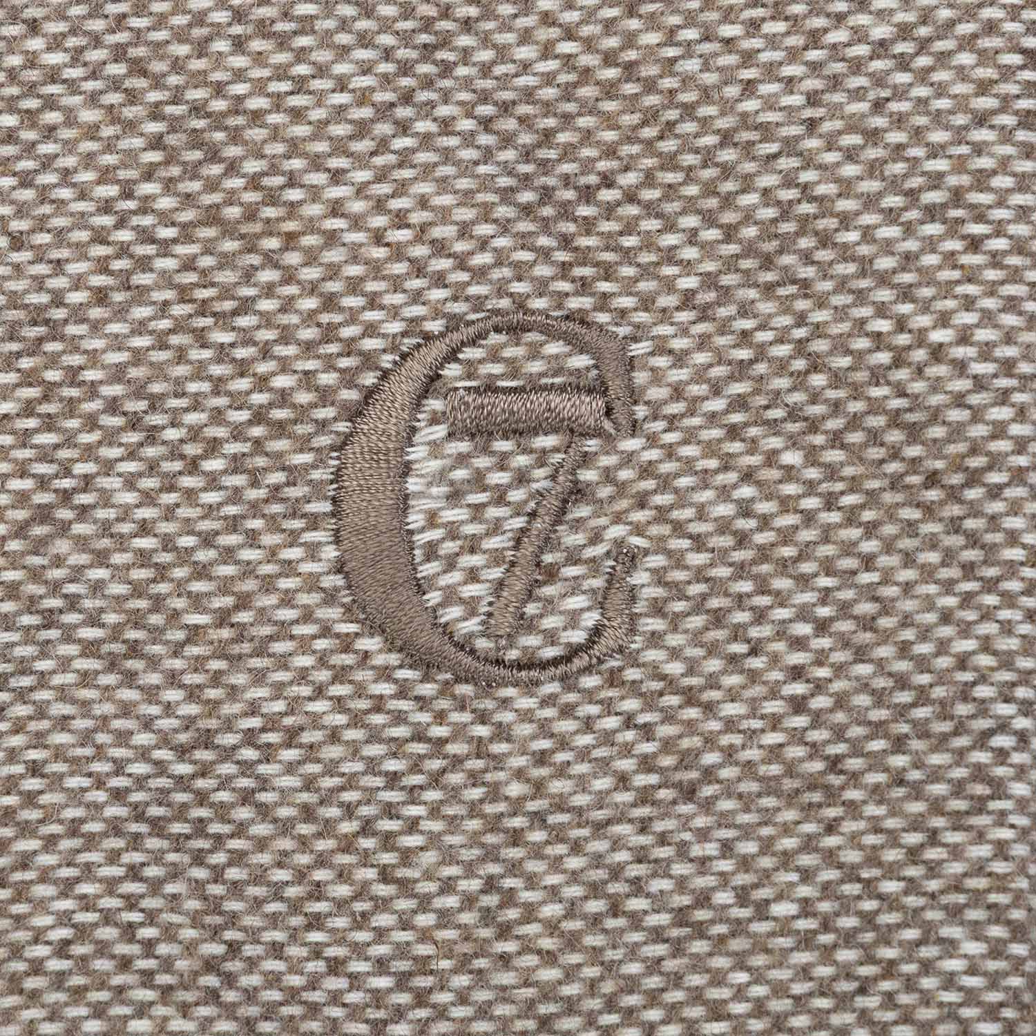 Close-up of a textured fabric surface with a logo or emblem.