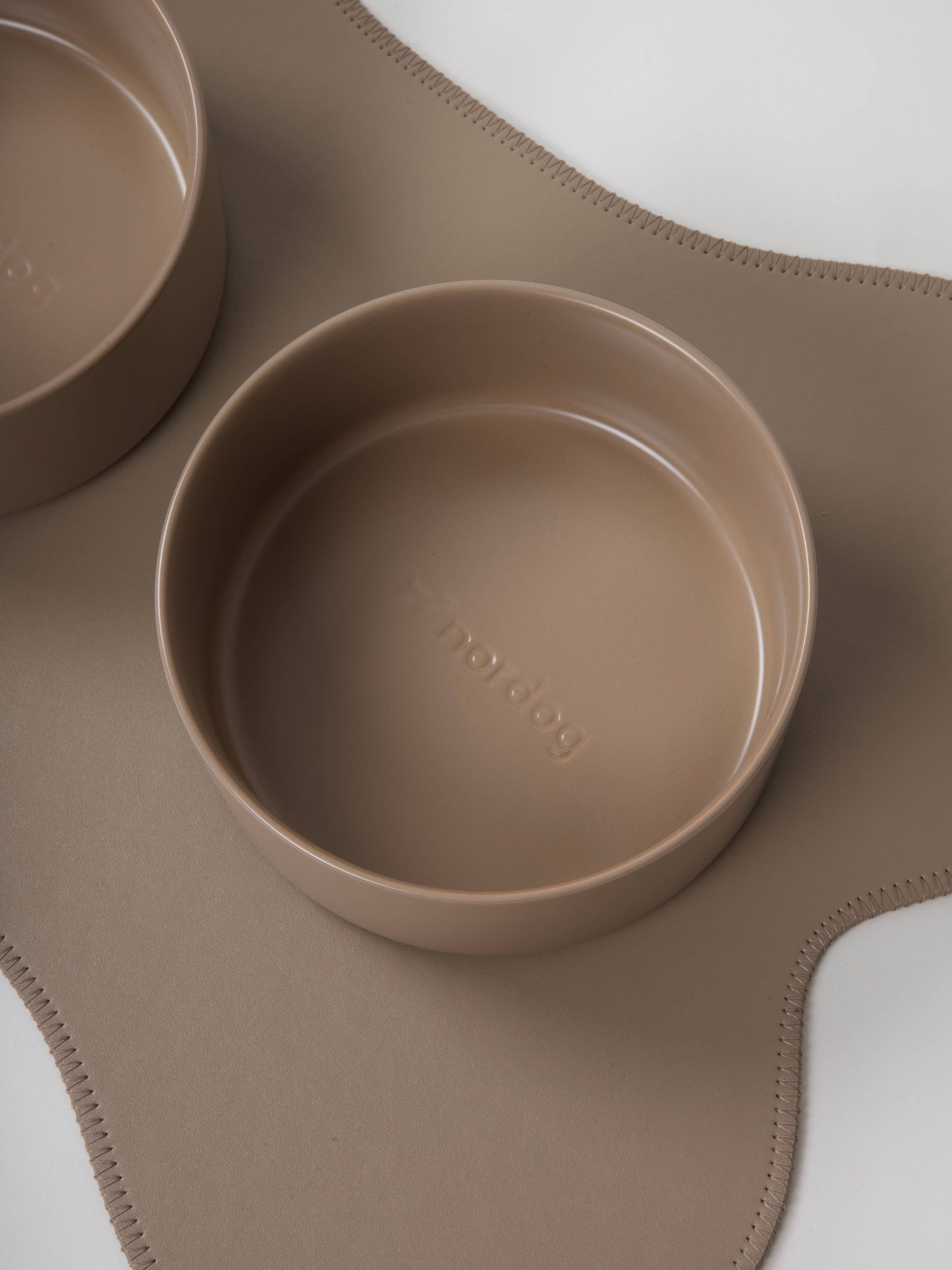 Beige silicone bowl and placemat on a light gray background