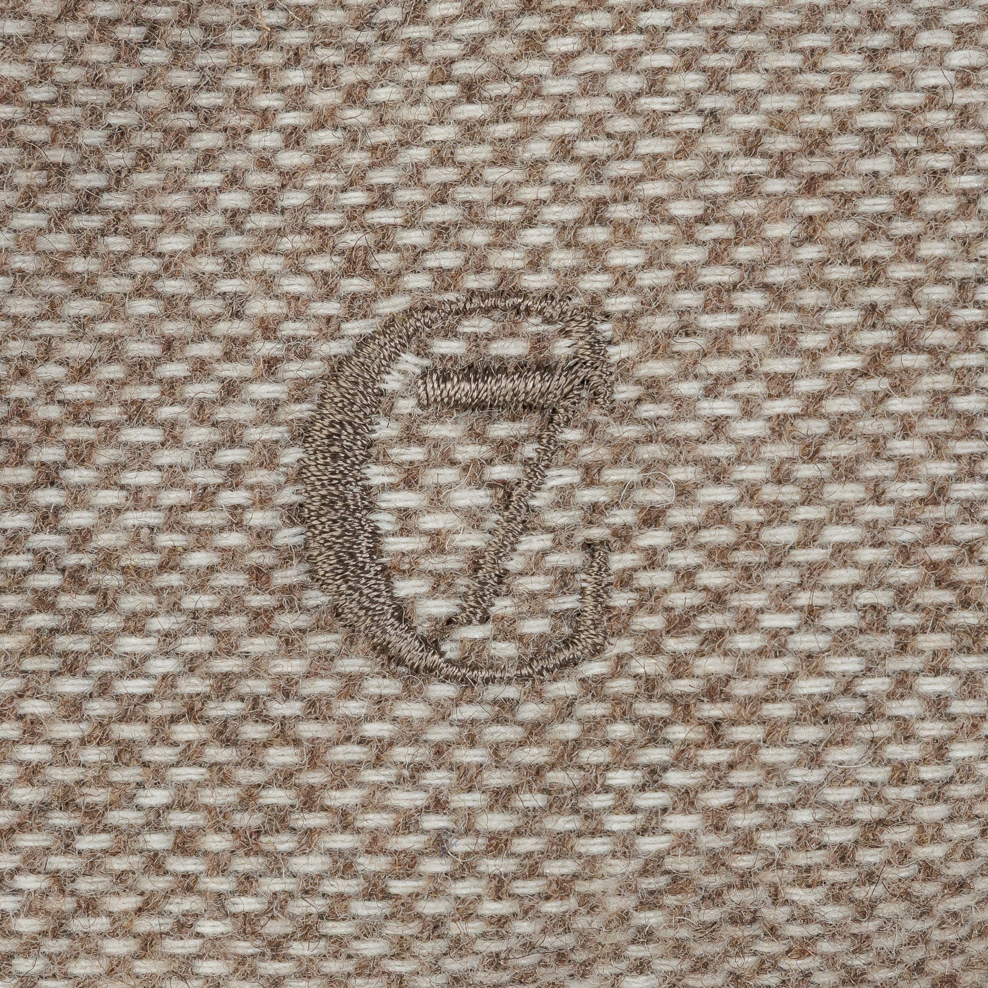 Close-up of a textured fabric with a logo in the center.