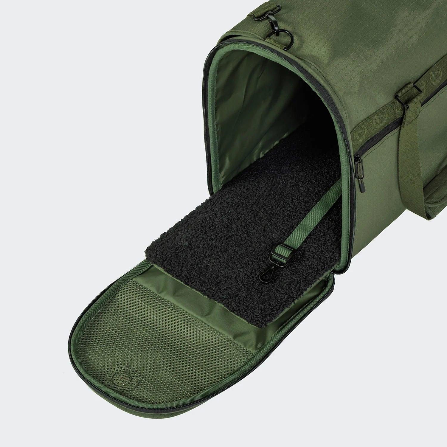 Green pet carrier with open door on a light gray background