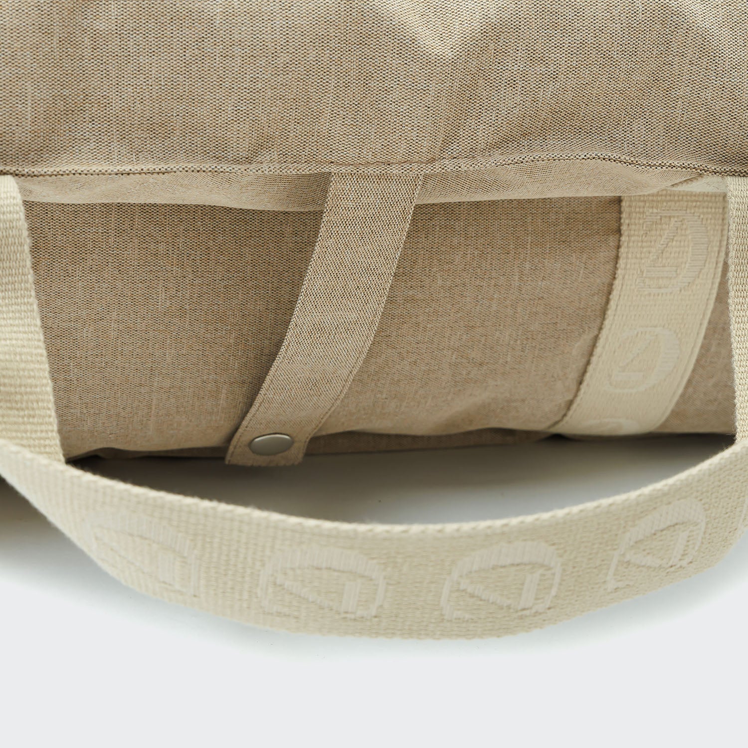 Close-up of a beige fabric bag with a button and brand logo on a white background