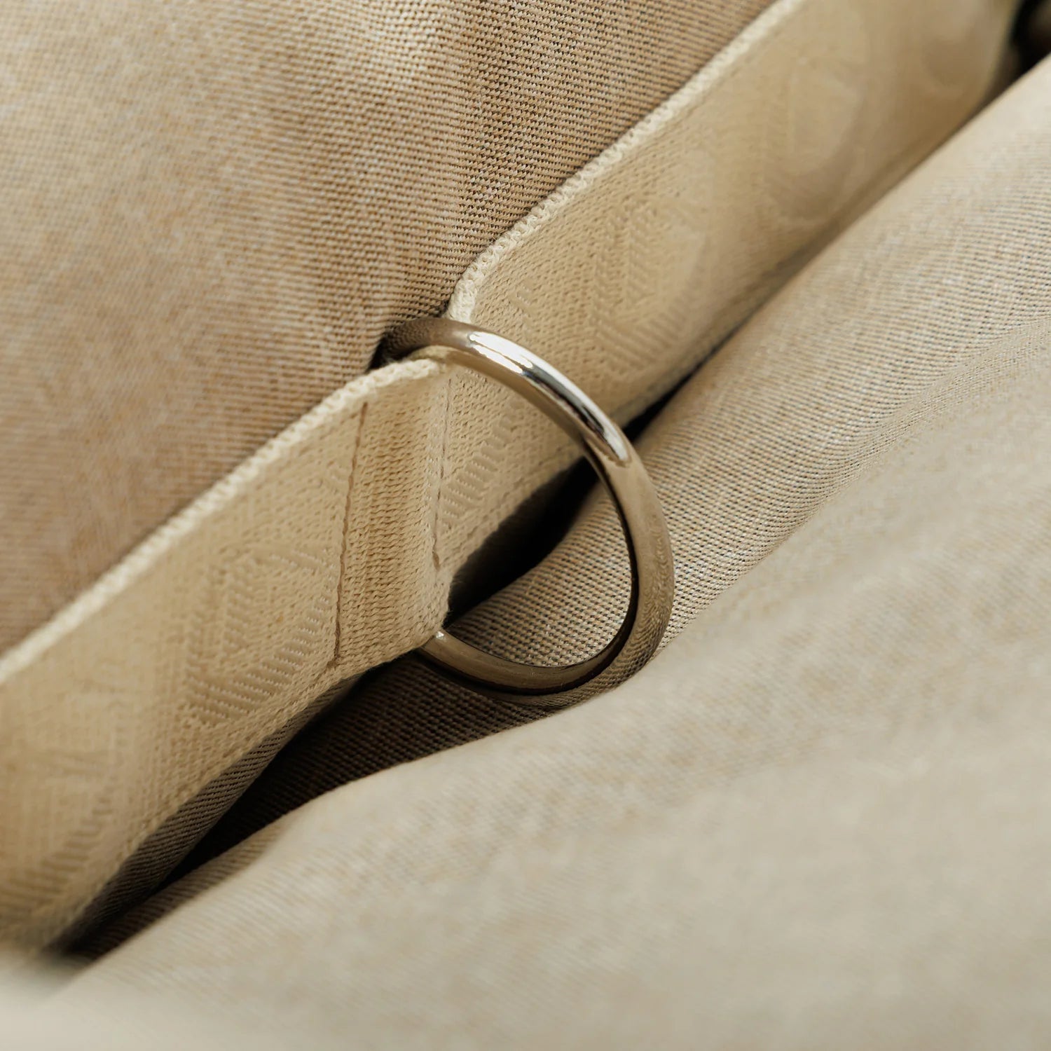 Close-up of a silver ring on beige fabric