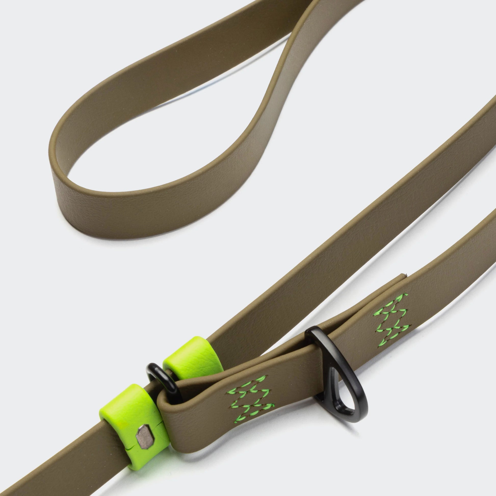 Brown dog leash with green accents on a white background