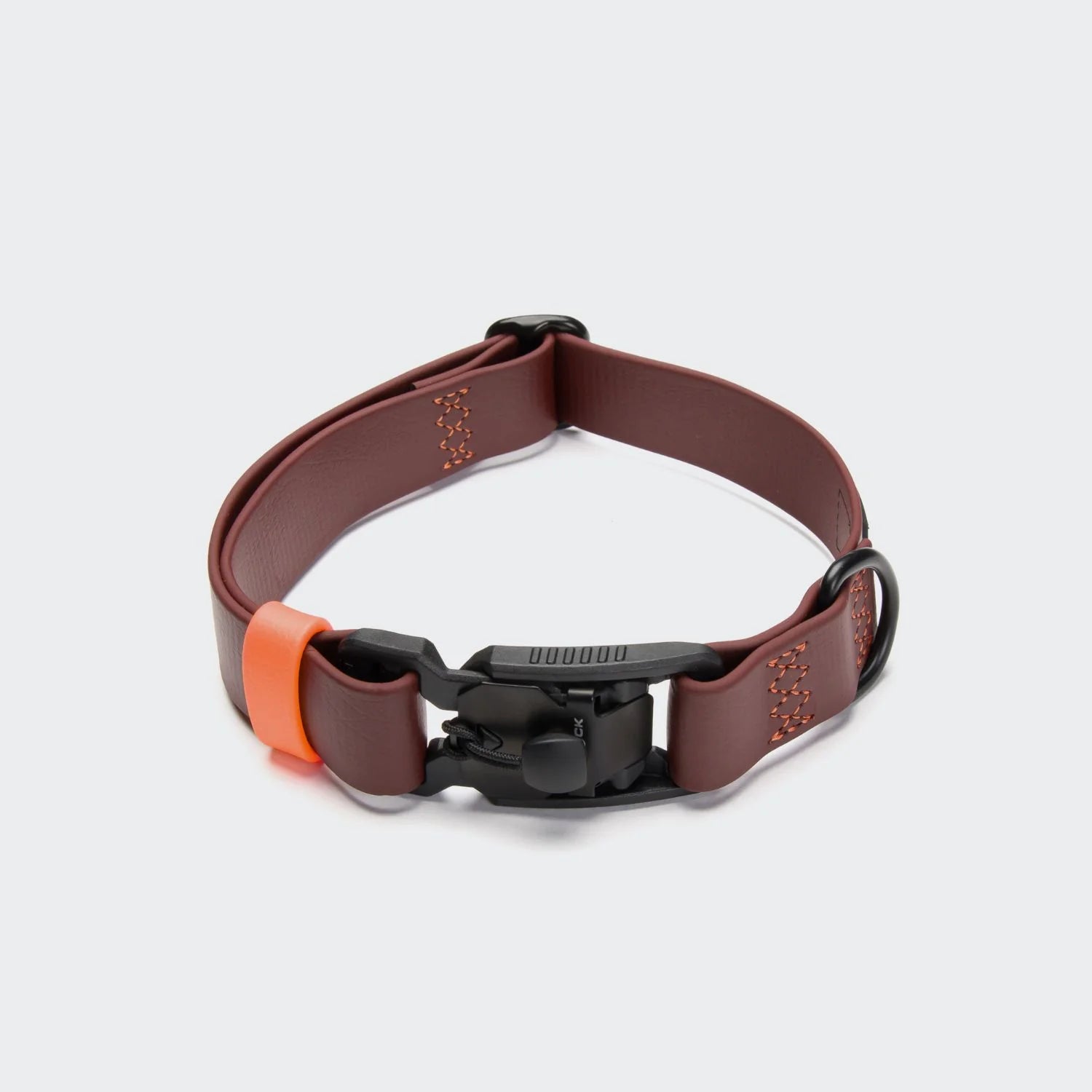 Brown dog collar with black buckle and orange accent on a light gray background