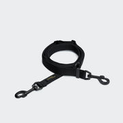 Black dog leash with clip on a light gray background