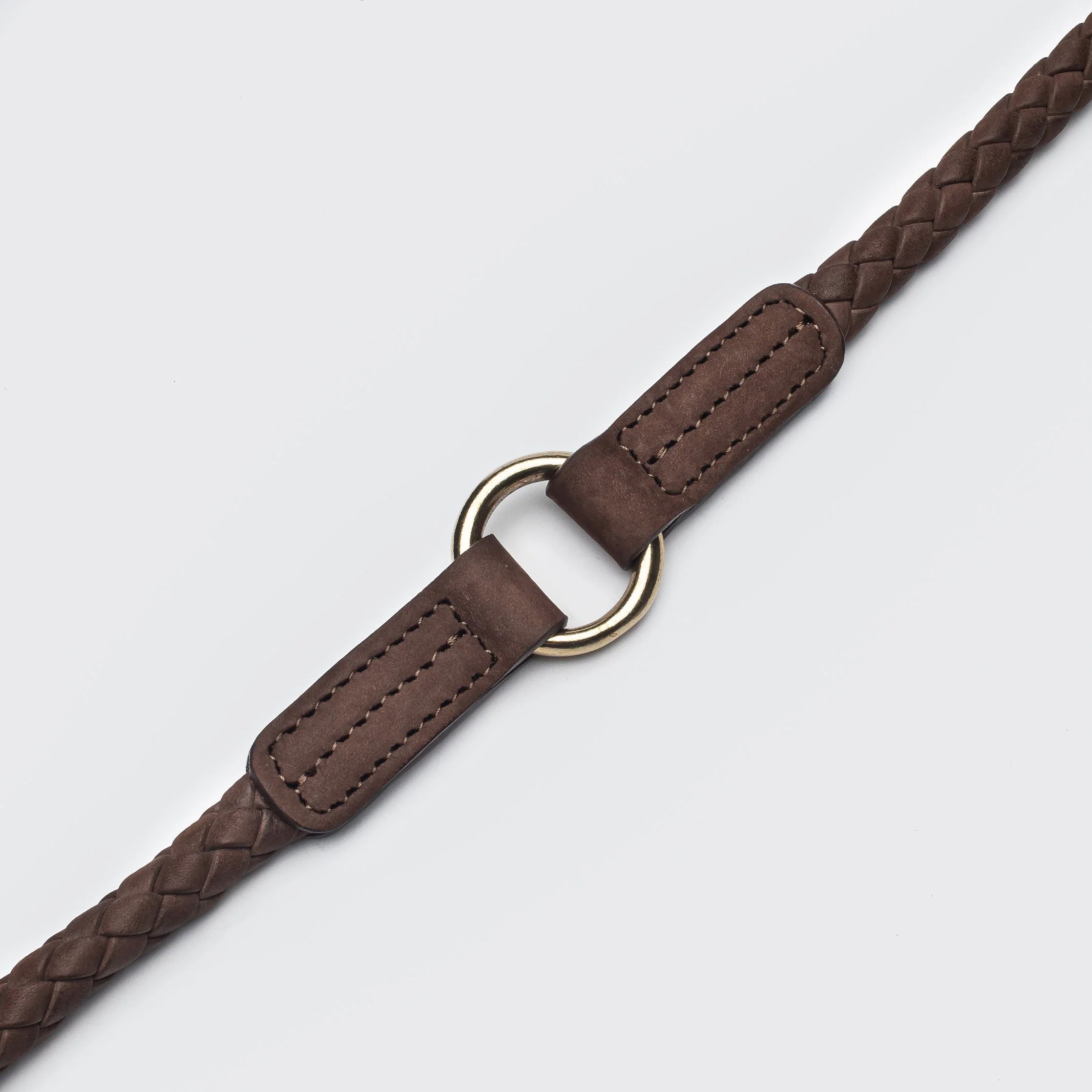 Close-up of handcrafted braided leather dog leash with brass fittings and premium Italian craftsmanship.