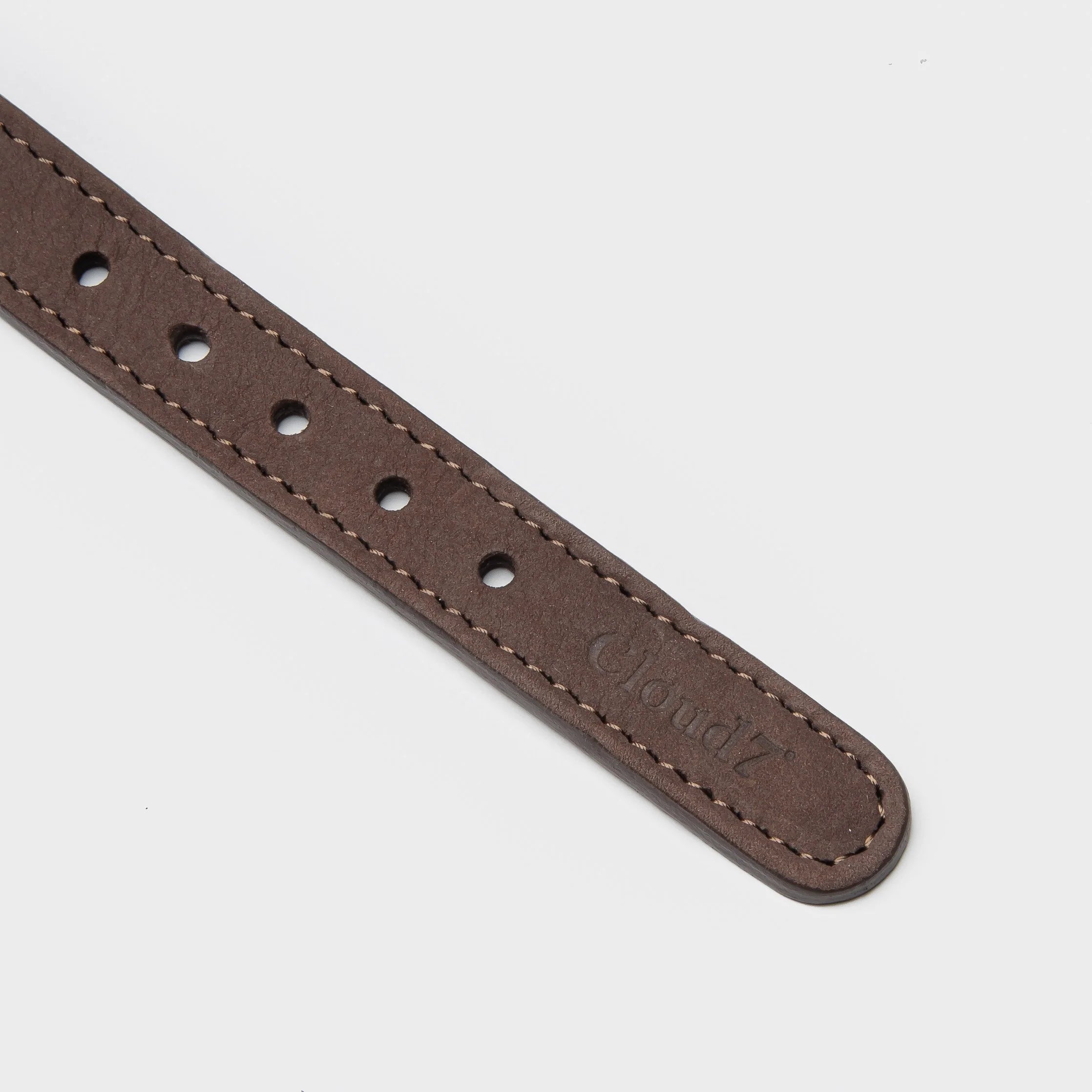 Brown leather strap with stitching on a light gray background