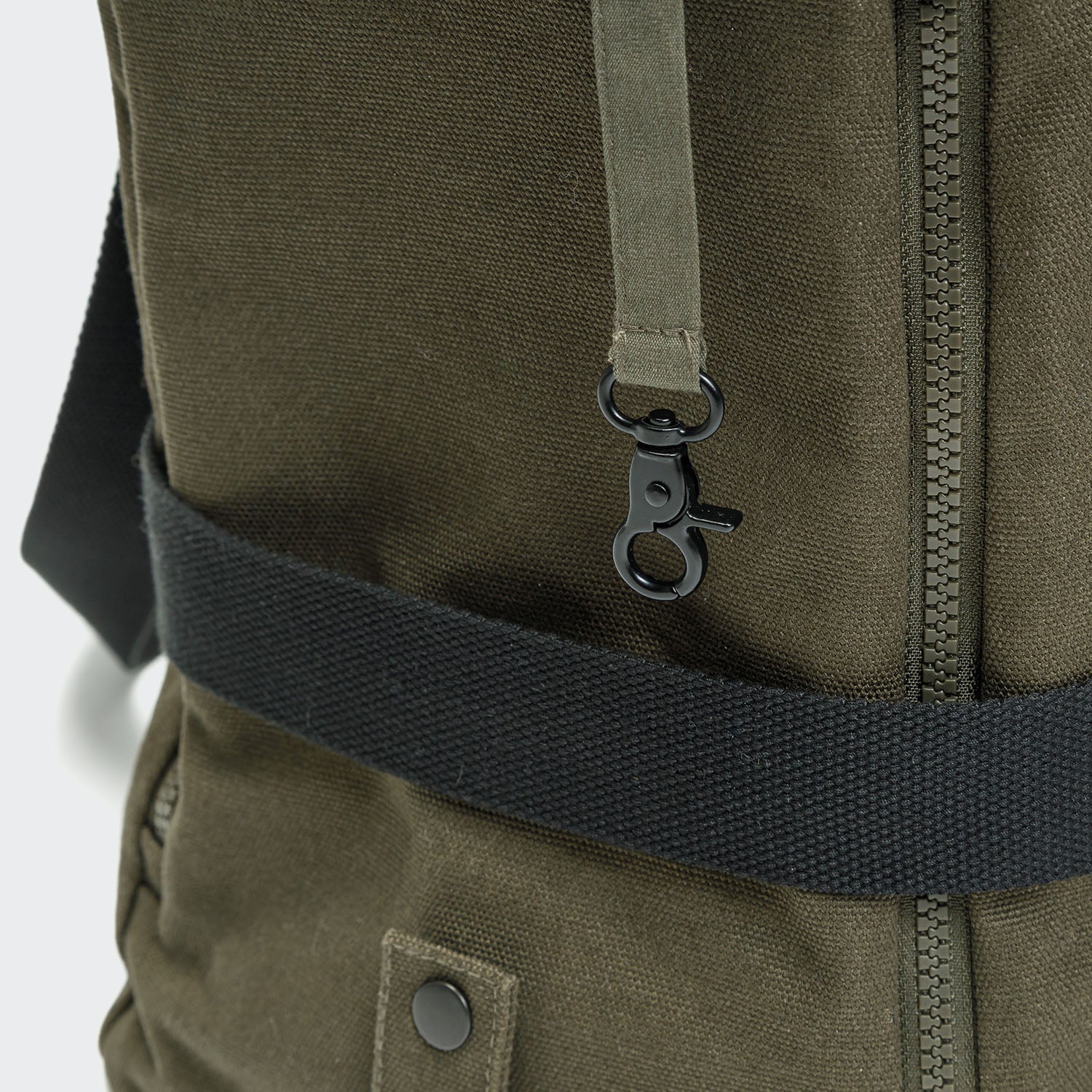 Close-up of a green backpack with a black strap on a white background