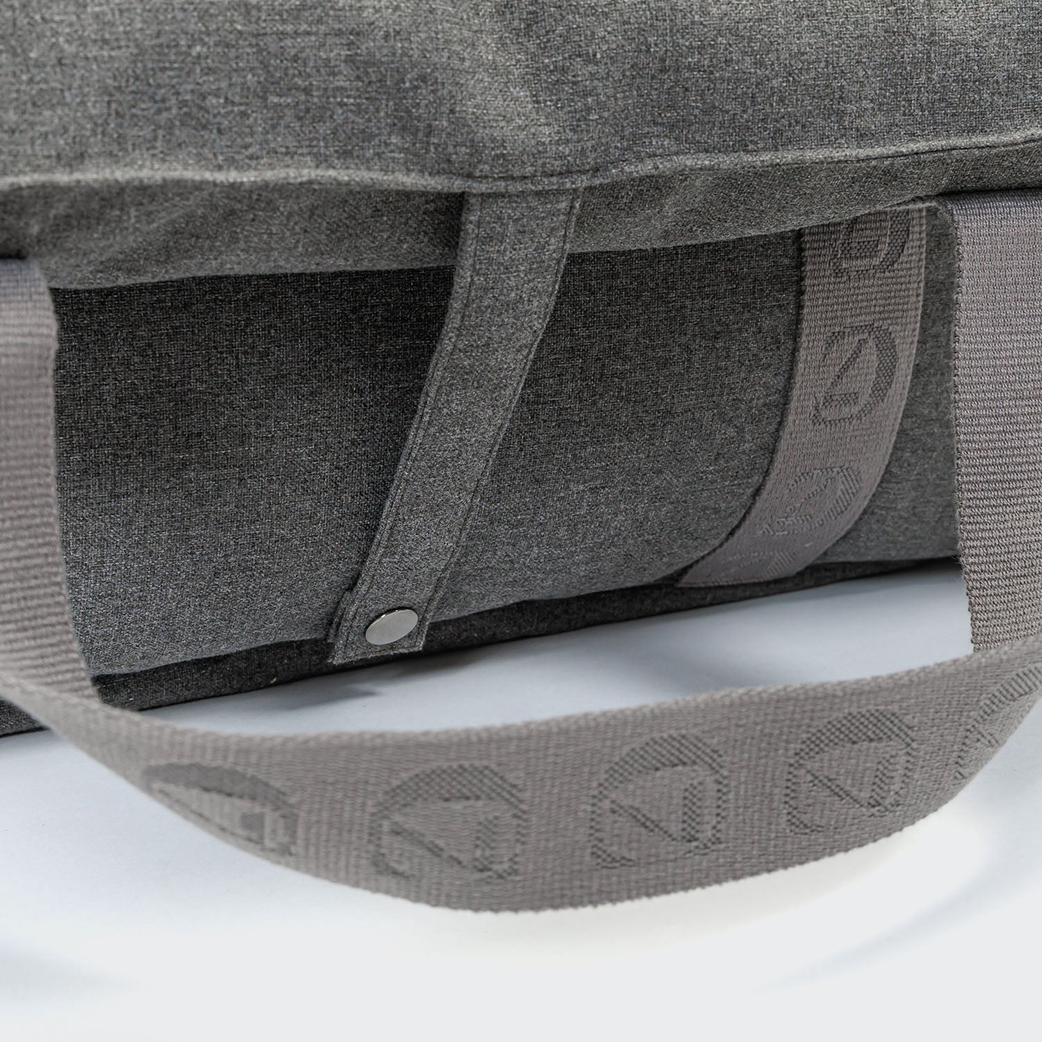 Close-up of a gray bag with branding on a white background