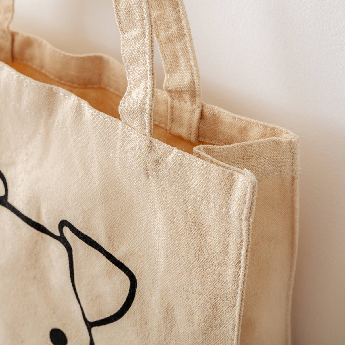 Foldable organic cotton everyday tote bag with dog-inspired design.
