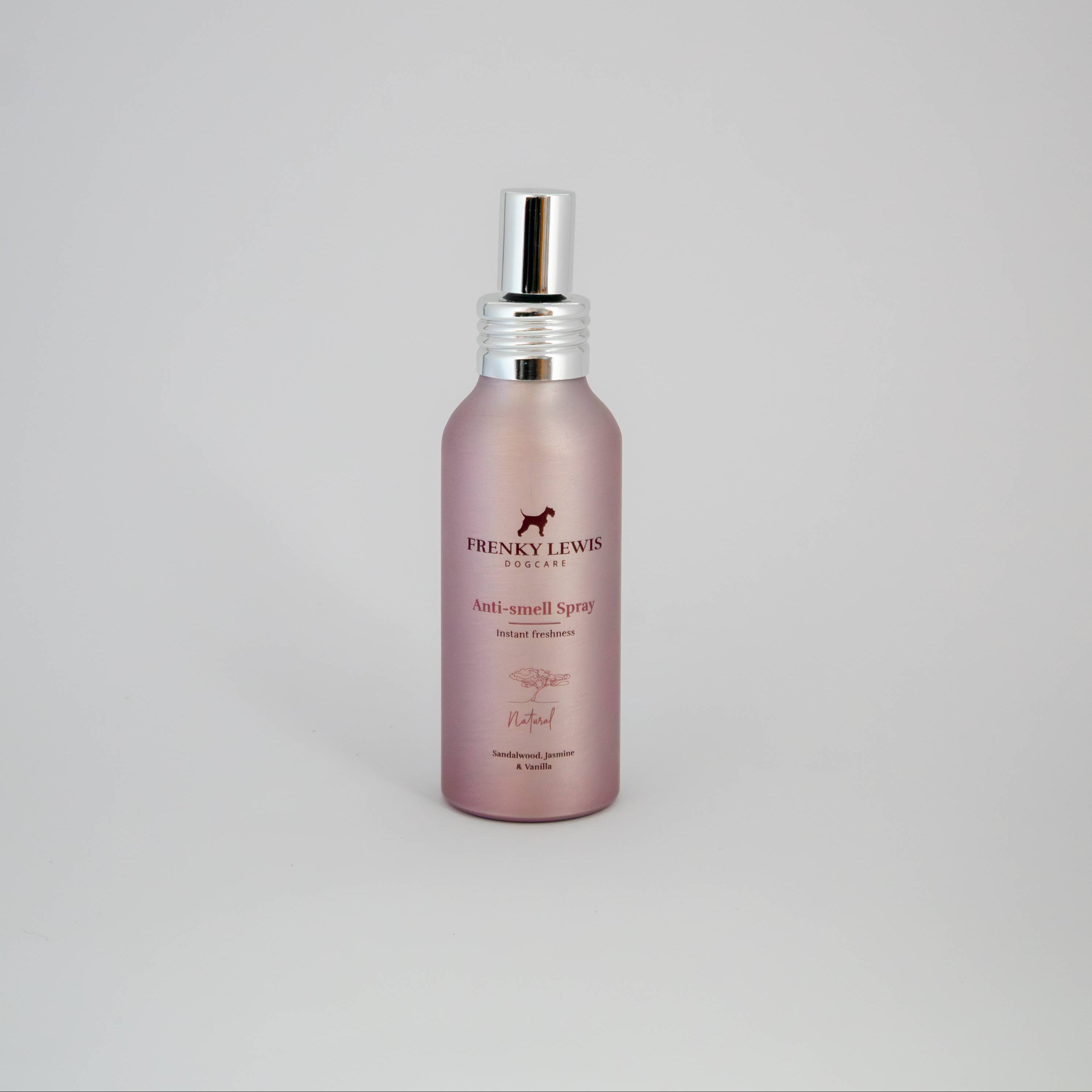 Pink spray bottle with silver nozzle on a light gray background