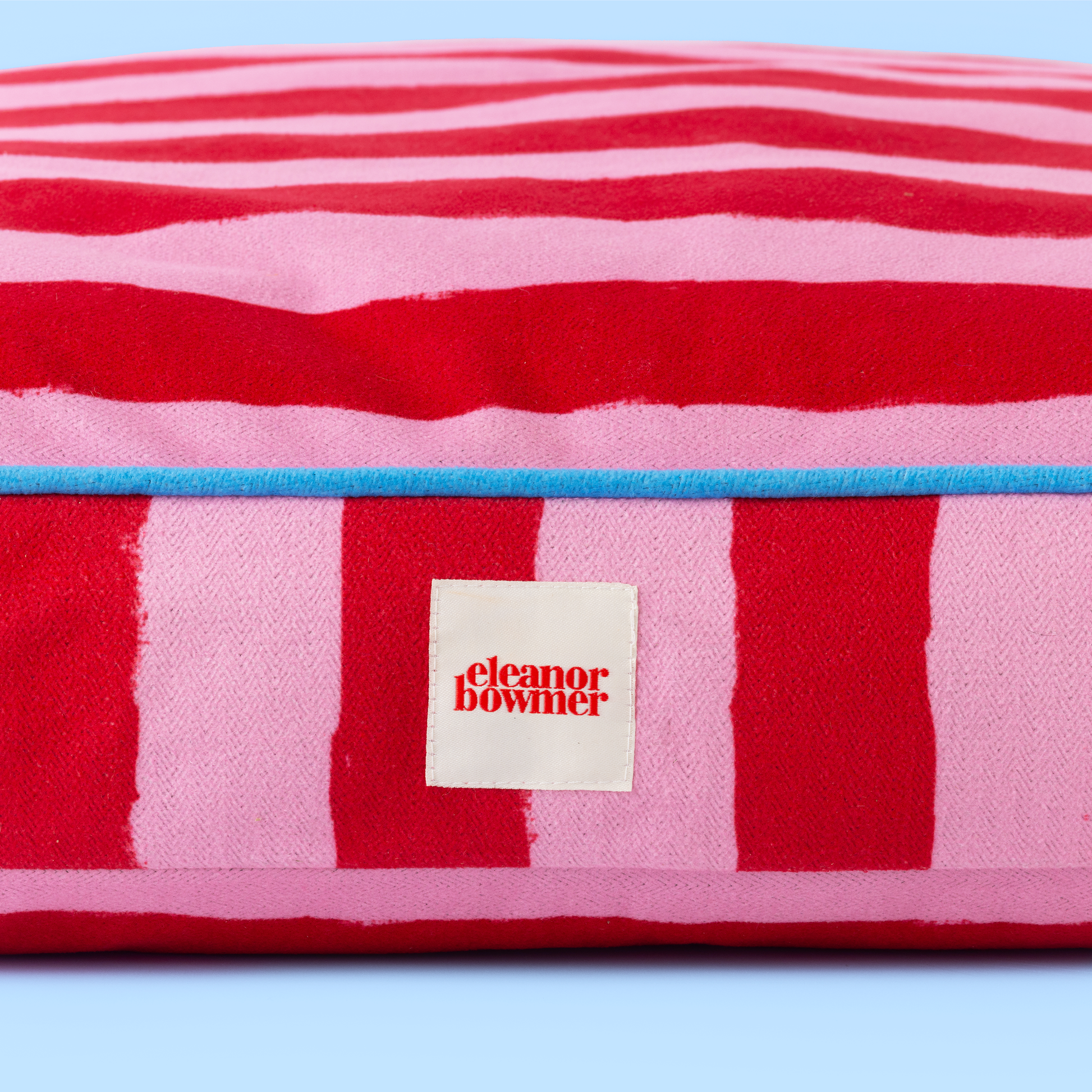 Red and pink striped towel with a label on a light blue background
