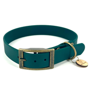 A dark teal green dog collar with an antique bronze rectangular buckle and a matching metal ring holding a small round branded tag, shown on a plain white background.