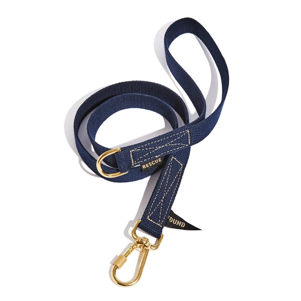 Navy blue dog leash with gold hardware on a white background