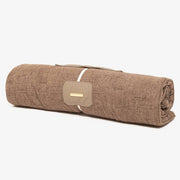 Rolled-up brown blanket with a patch on a white background