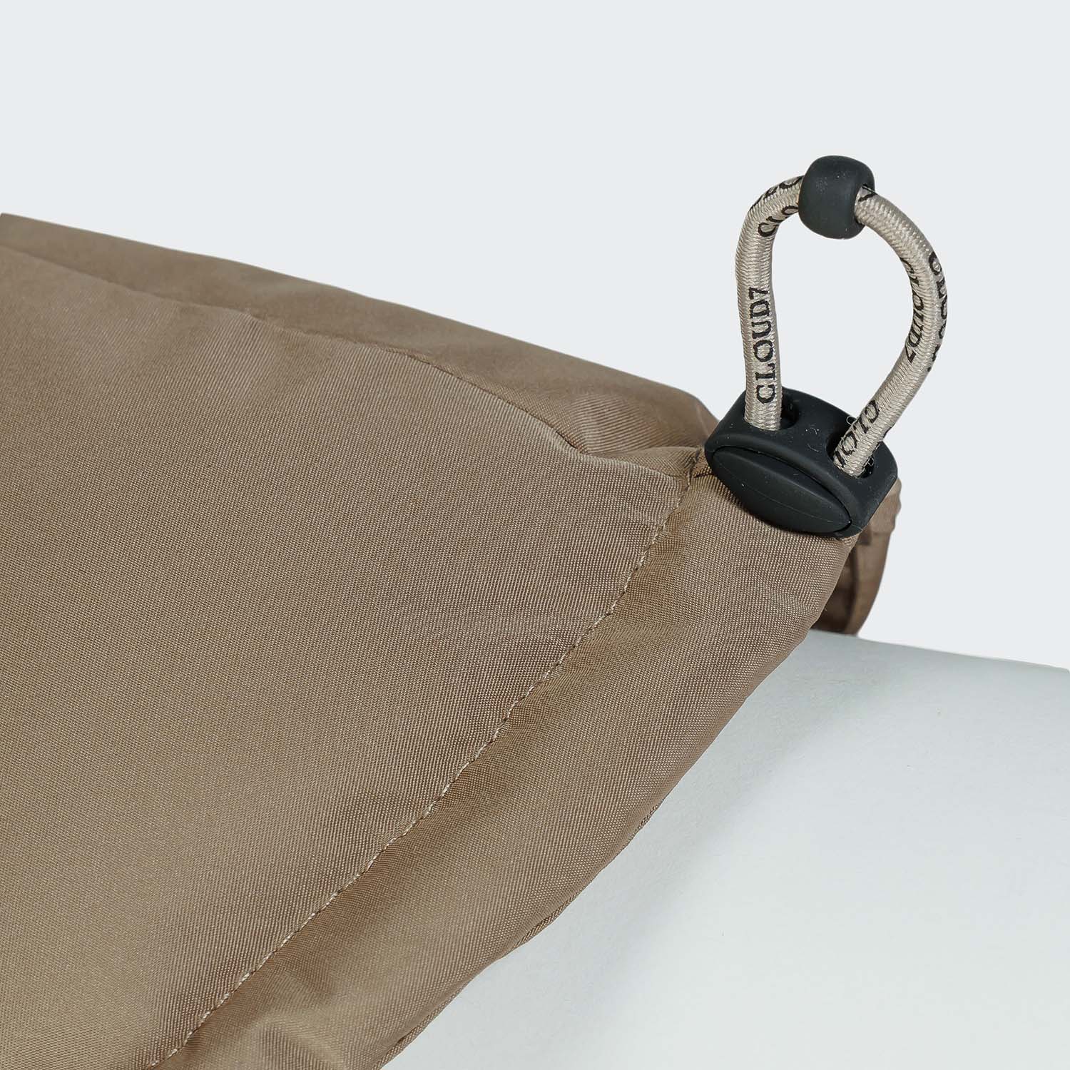 Close-up of a beige fabric with a black and silver clasp on a white background