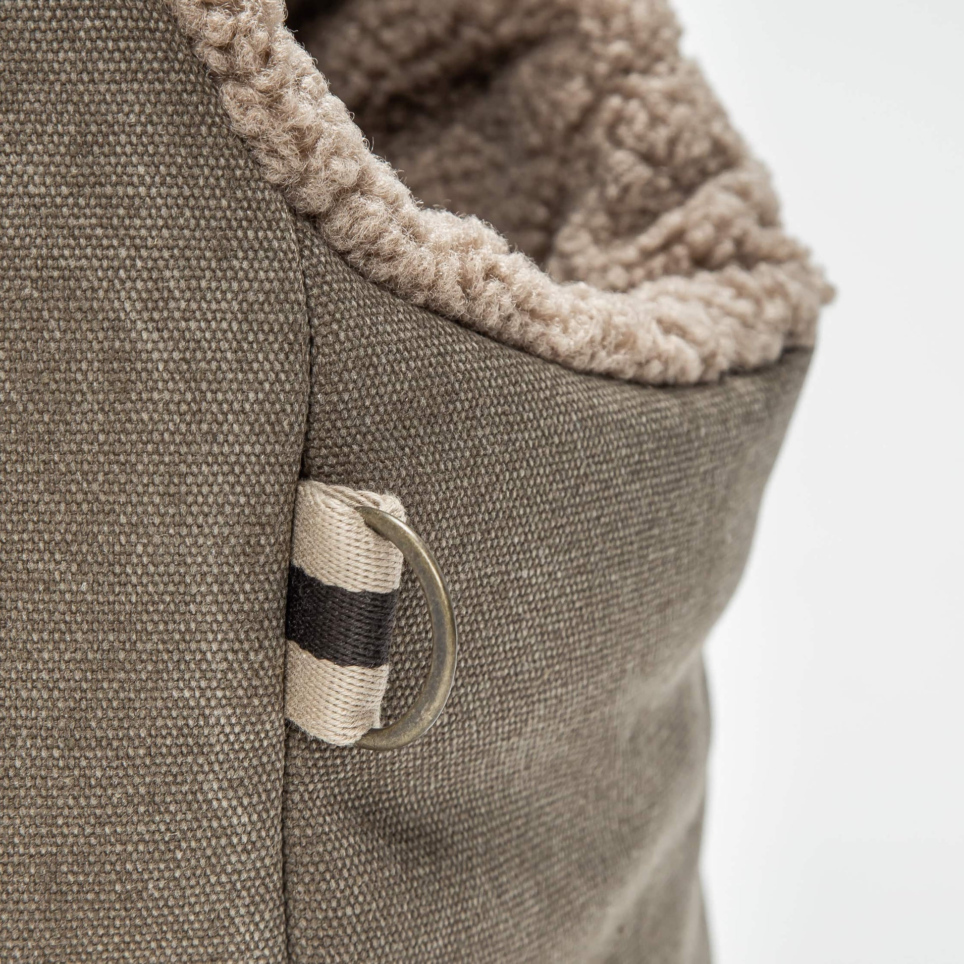 Close-up of a brown pet bed with a textured surface and a visible brand label.