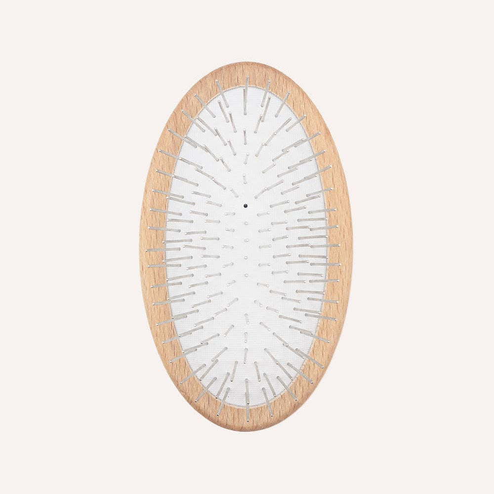 Rounded metal pin brush for removing loose hair and preventing tangles in long-haired dogs.