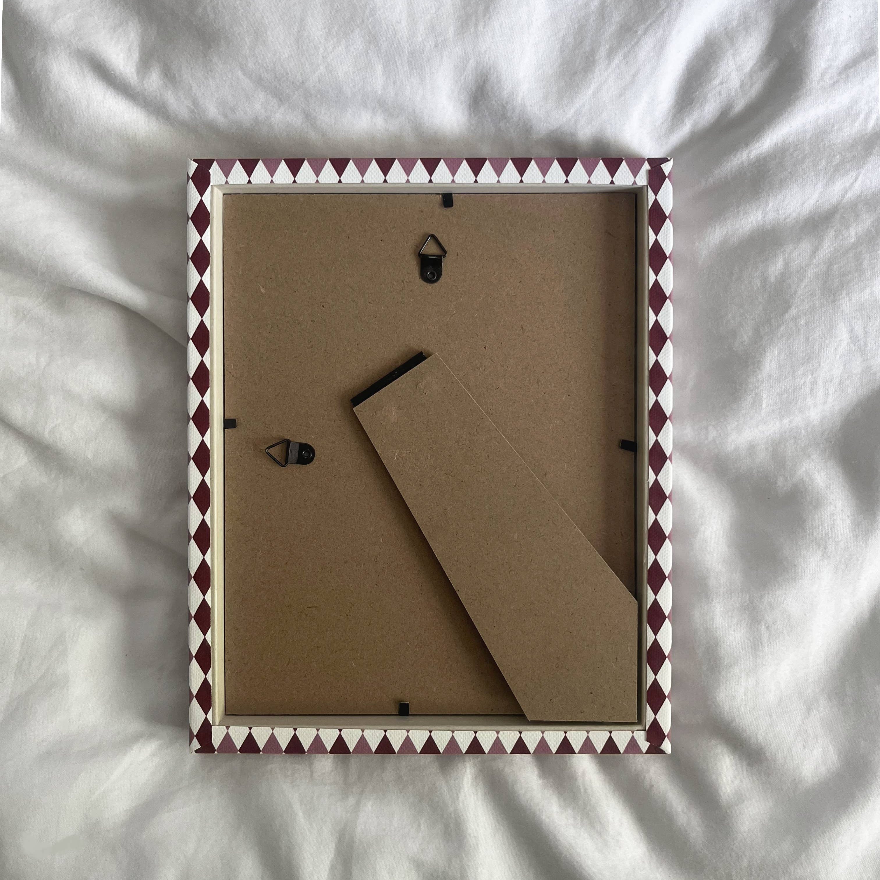 Contemporary cotton fabric picture frame with burgundy and blush harlequin design.