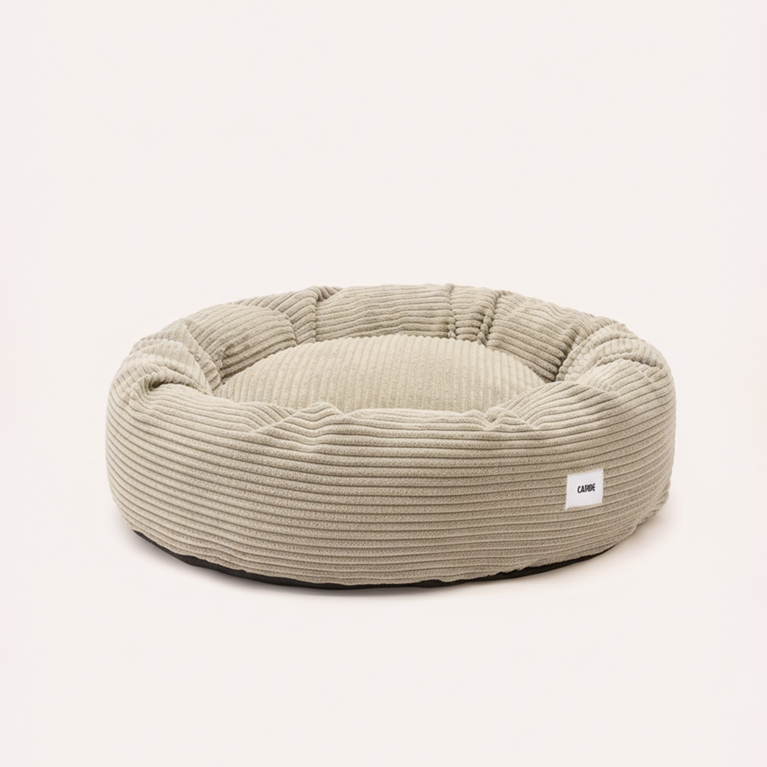 Soft round corduroy dog bed in beige with raised sides for added comfort.