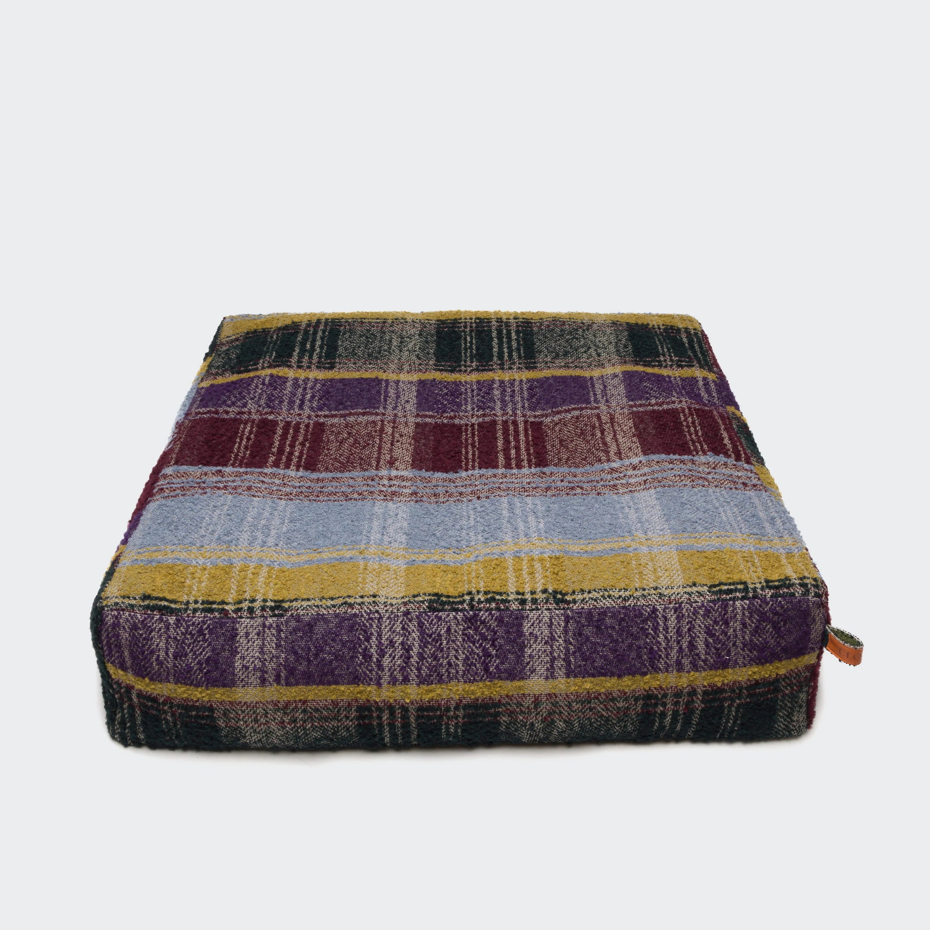 Plaid patterned dog bed on a white background