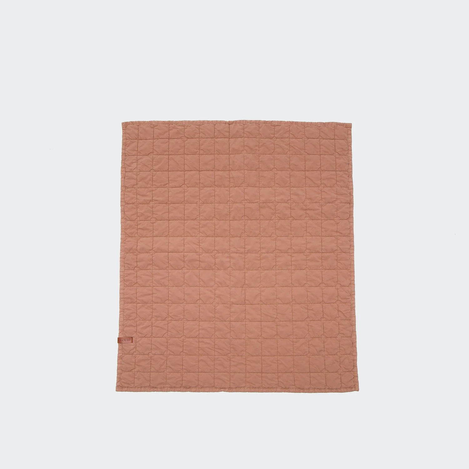 Quilted blanket with a subtle pattern on a light gray background