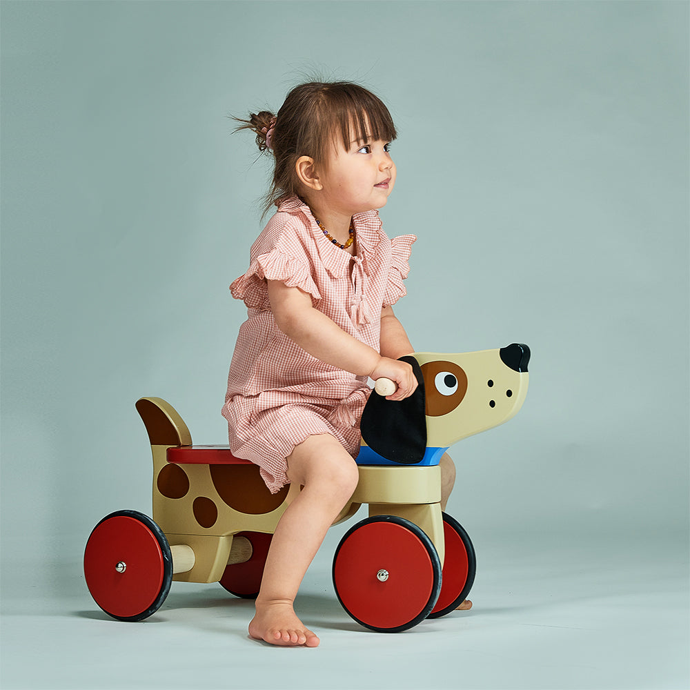 Wooden dog ride on toy with four wheels and soft fabric ears by Mentari