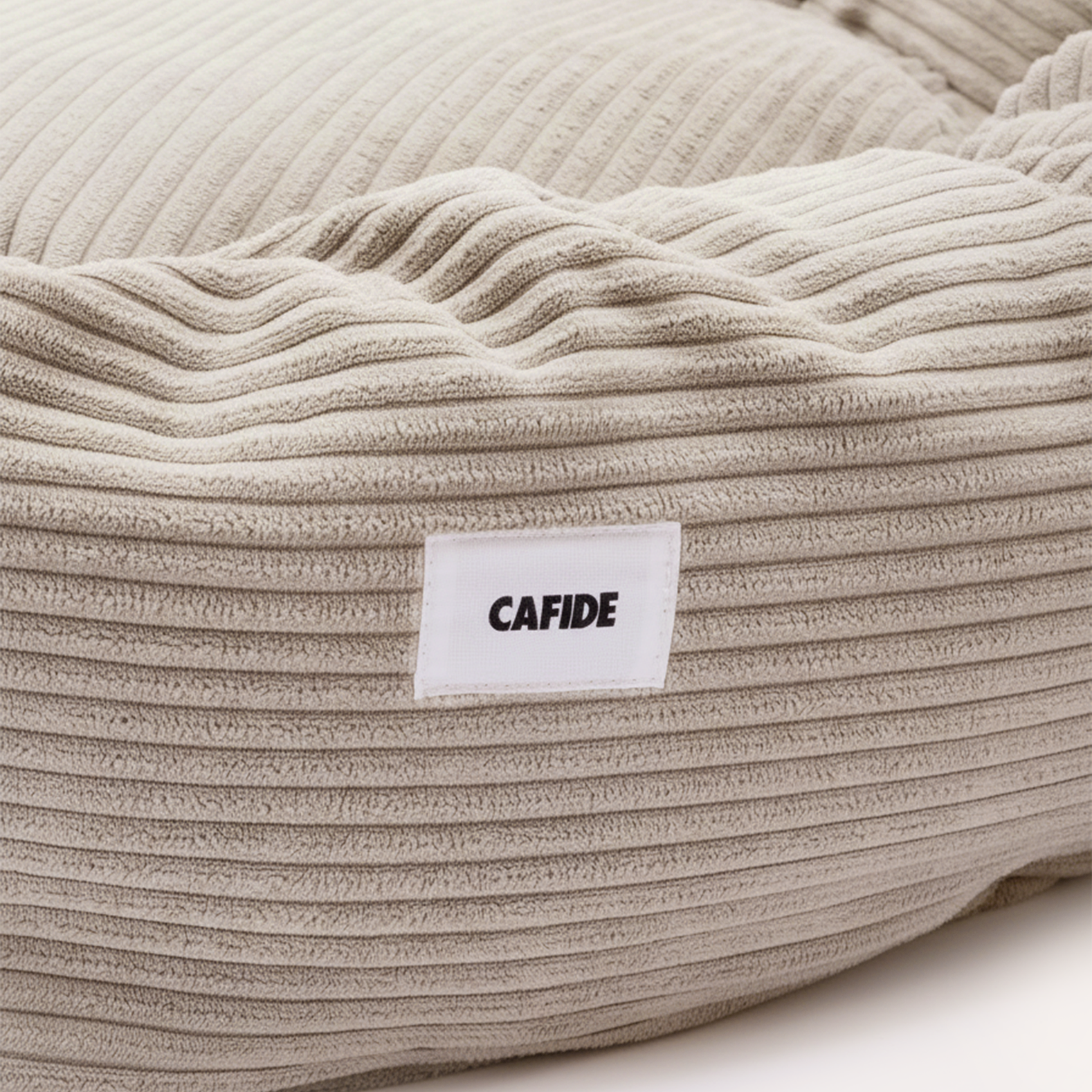 Contemporary round dog bed upholstered in premium beige corduroy fabric.