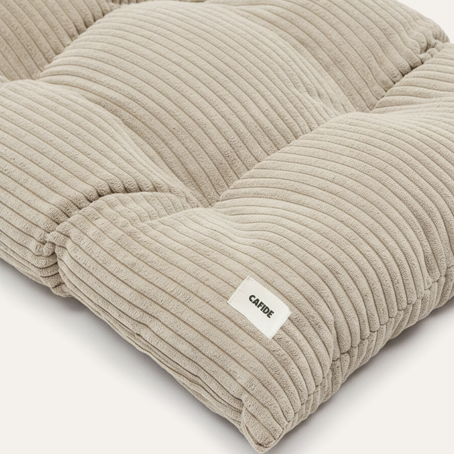 Premium beige dog bed cushion with plush corduroy upholstery and minimalist styling.