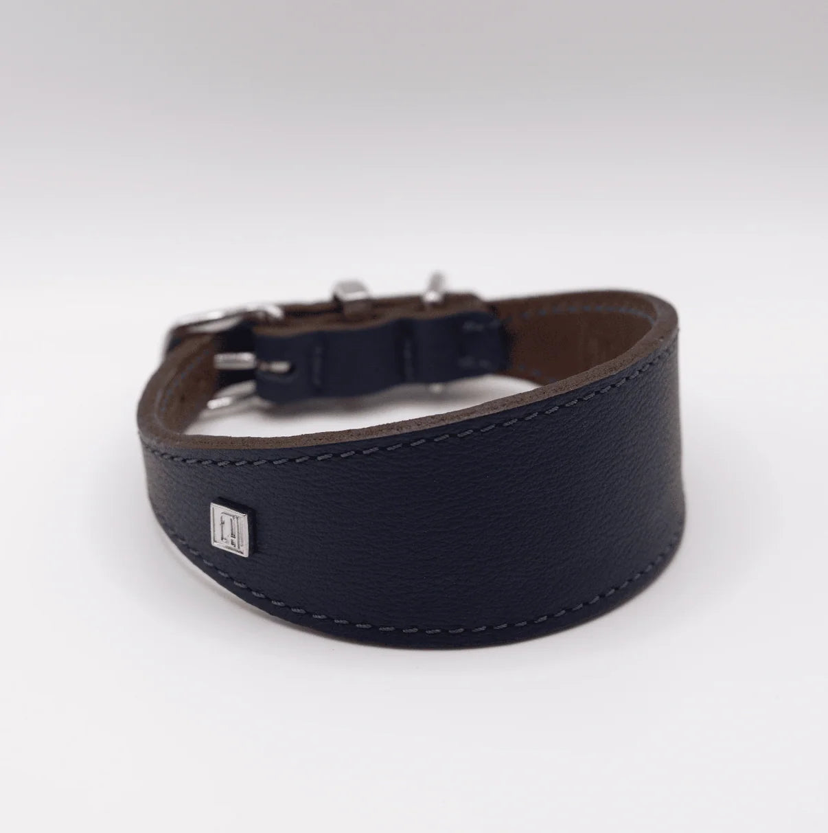 Navy leather dog collar with a silver buckle on a white background