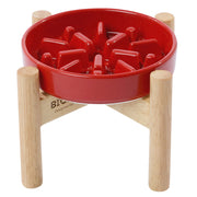 Red ceramic Pehom Spark slow feeder dog bowl with natural wooden stand for small dogs.