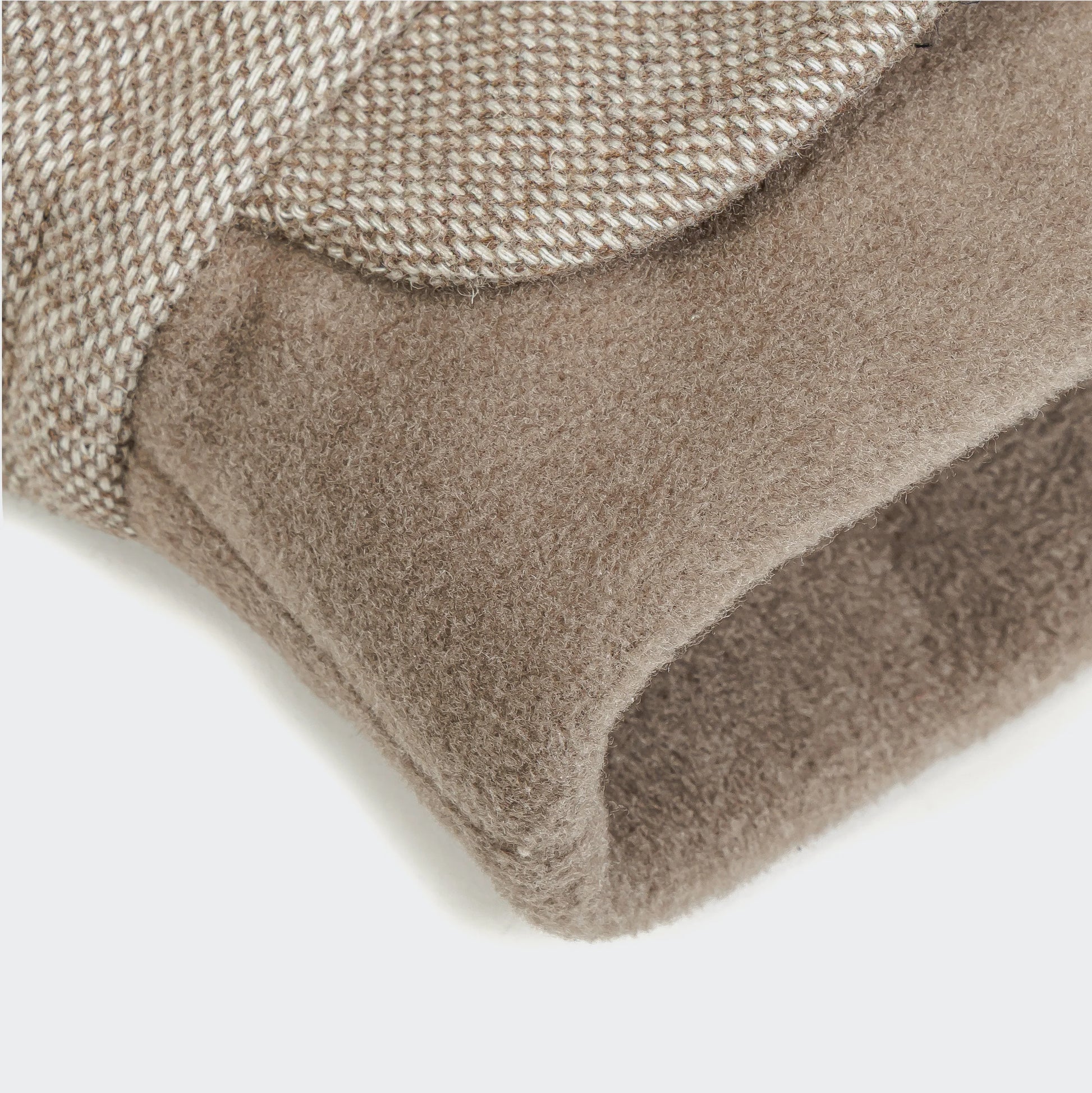 Close-up of a textured brown rug corner on a white background