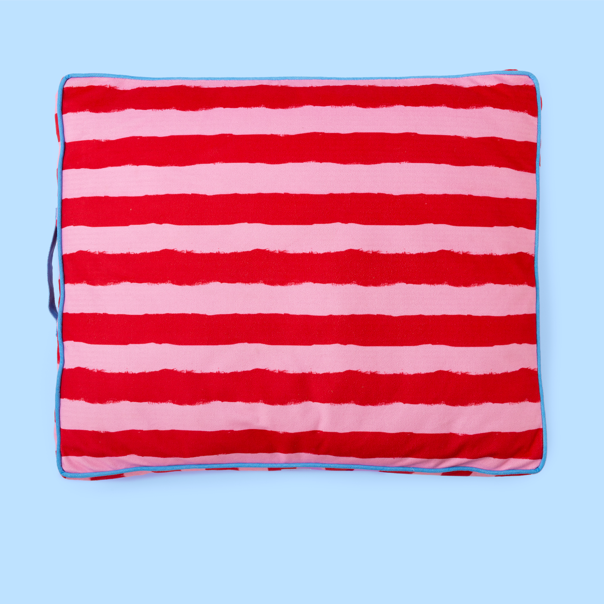 Red and pink striped blanket on a blue background