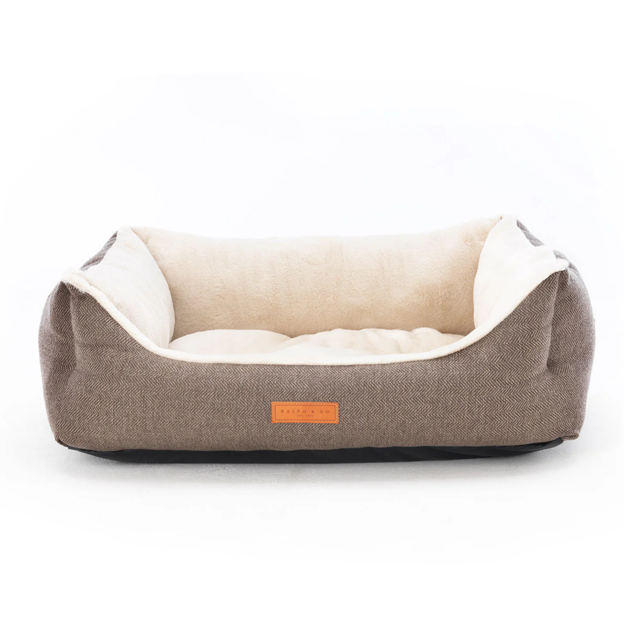 Pet bed with a beige fabric exterior and white interior on a white background