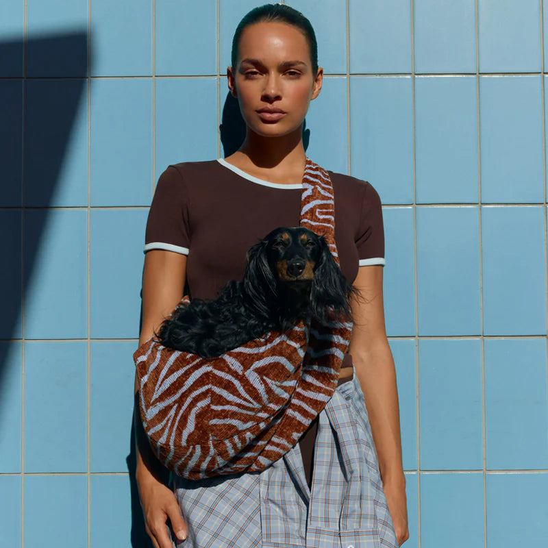 Stylish dog carrier with an adjustable internal safety strap and clip.