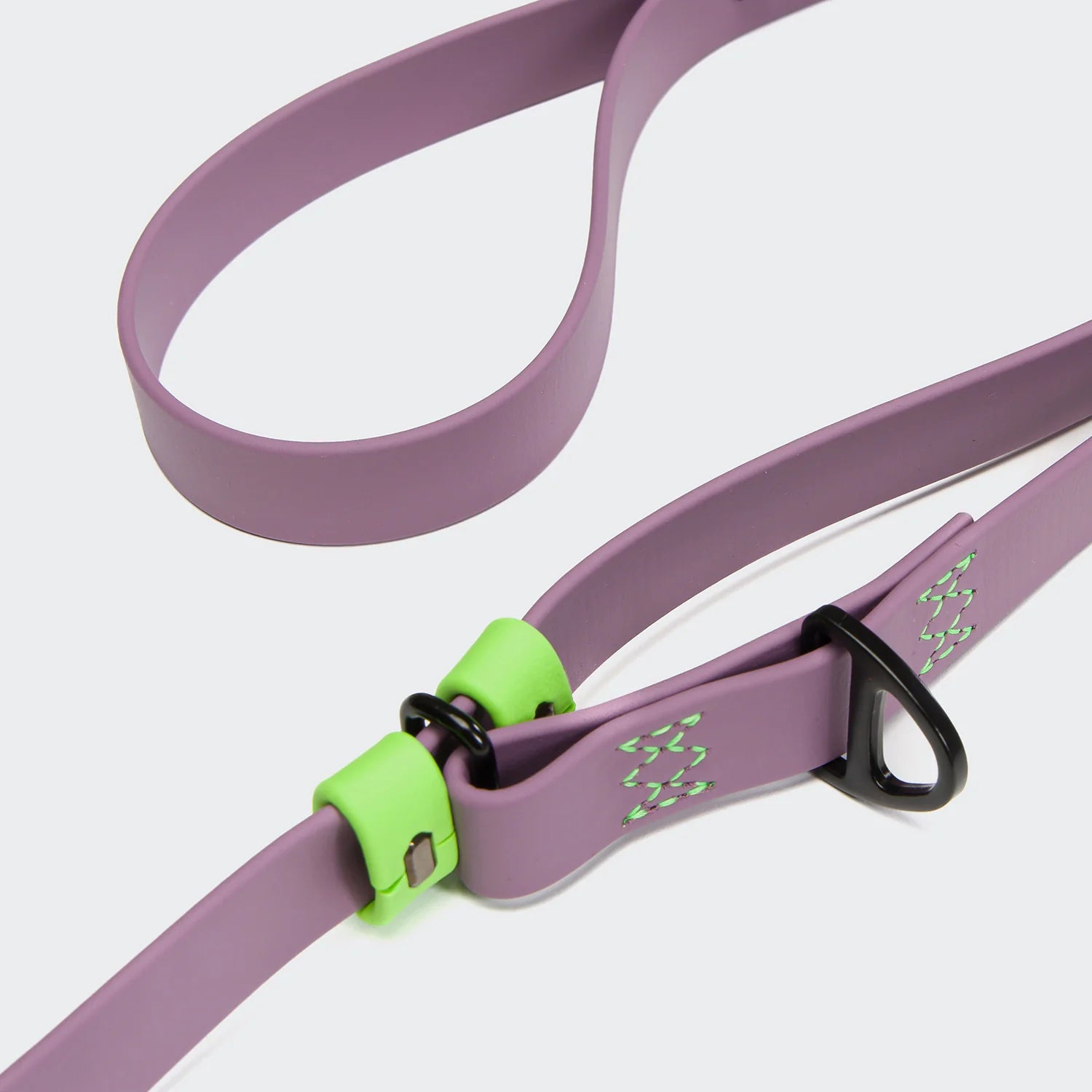 Purple dog leash with green clip on a light gray background