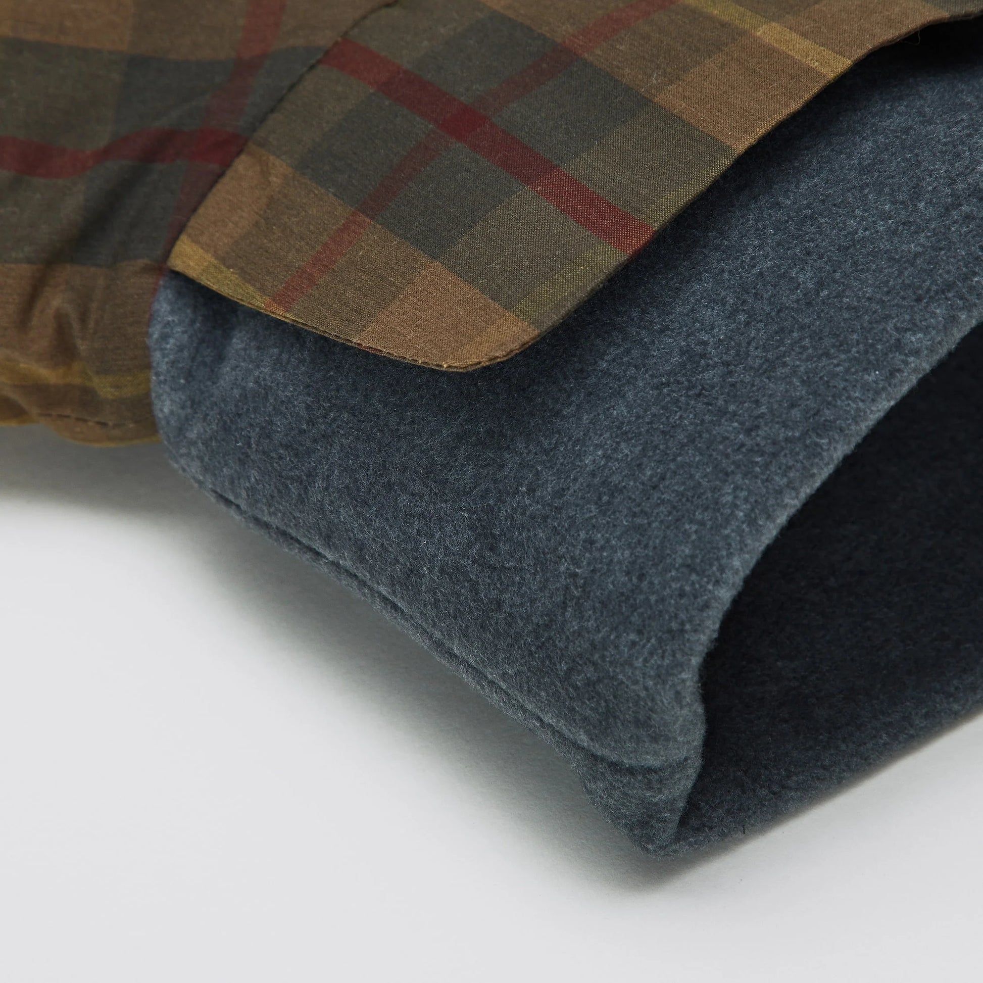 Close-up of a plaid fabric with a dark gray texture on a white background