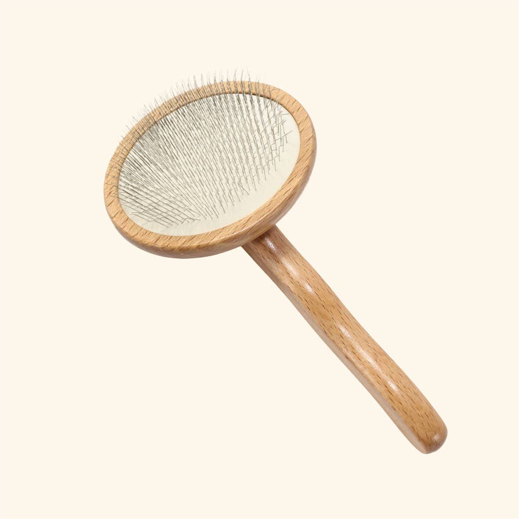 Wooden dog grooming slicker brush with cushioned pad and soft retracting pins.