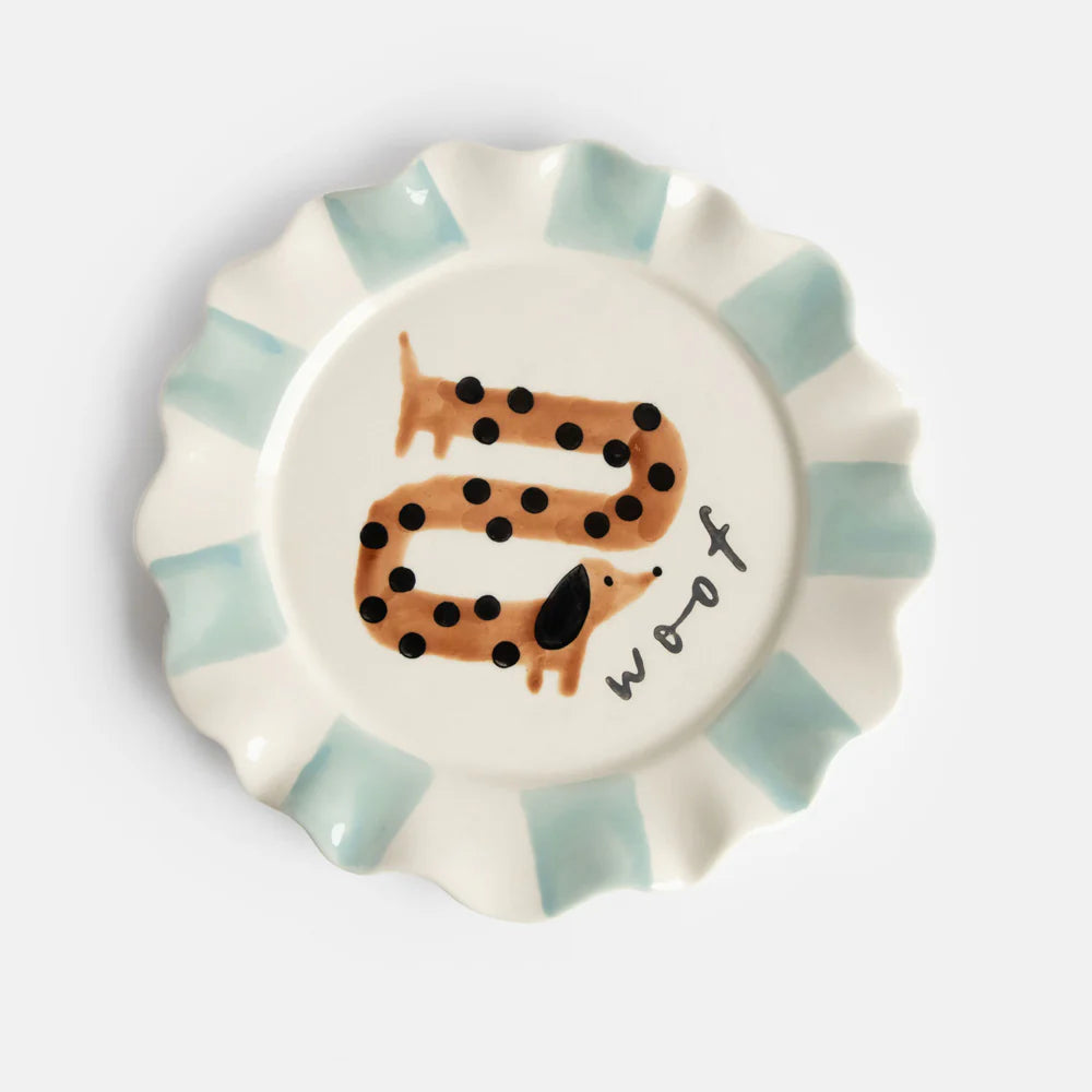 Hand-painted Woof Sausage Dog ceramic plate with scalloped blue rim from Bell & Beau.