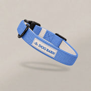 Blue dog collar with a visible 'DOG BARN' label on a gray background