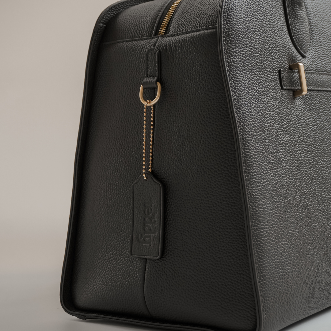 Gray leather bag with a visible brand tag on a neutral background