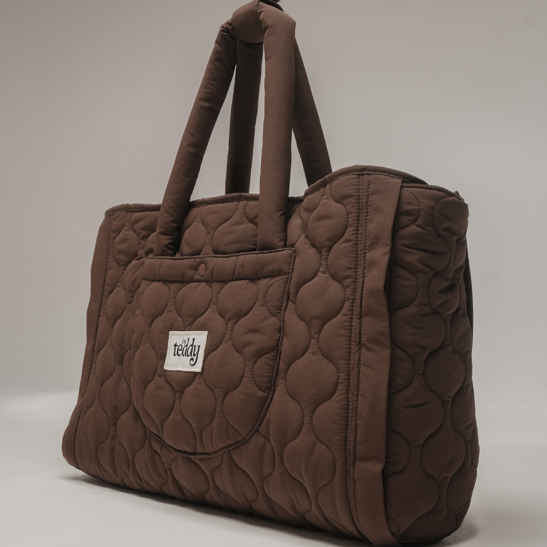 Brown quilted handbag with a visible brand logo on a neutral background