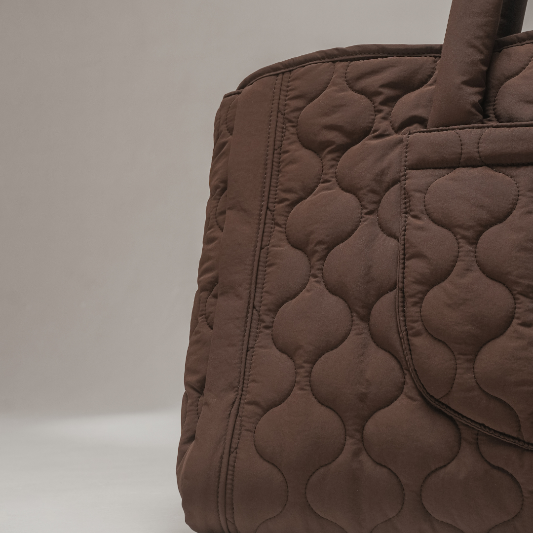 Brown quilted bag on a light gray background